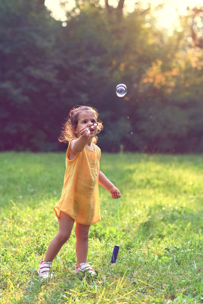 Sabun balonları ile oynarken küçük kız. — Stok fotoğraf