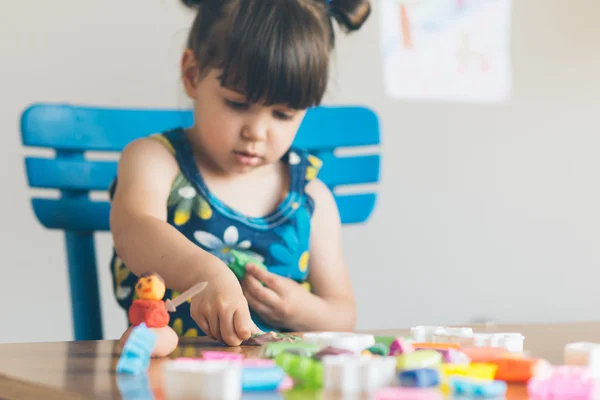 Meisje spelen met play dought in haar huis gesneden — Stockfoto