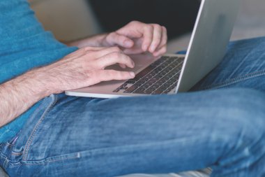 Genç adam evde çalışıyor.