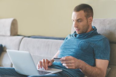 Genç adam evde çalışıyor.