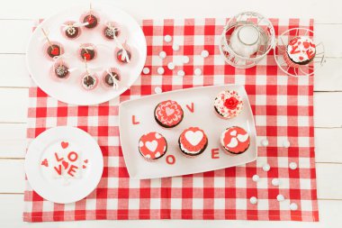Eski ahşap masa üzerinde kırmızı beyaz sarmalayıcı cupcake..