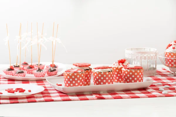 Cupcake dans l'emballage blanc rouge, sur la vieille table en bois .. — Photo