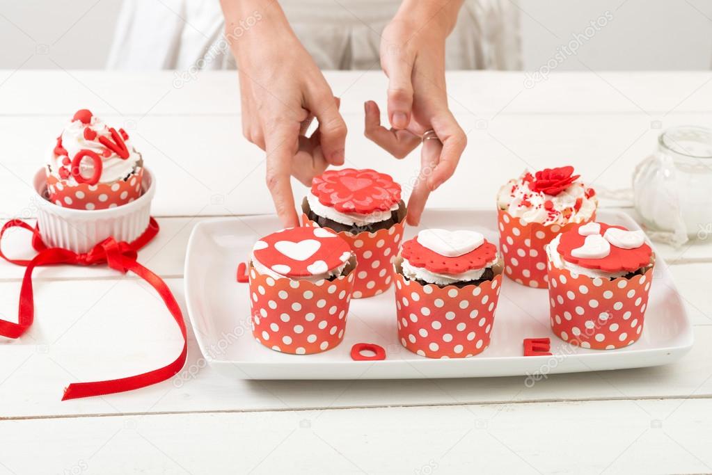 Cupcake in the red white wrapper, on the old wooden table.