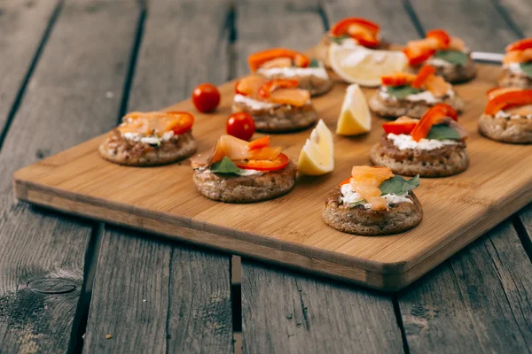 Ciegos en la mesa de madera. Sandwich de salmón  ... — Foto de Stock