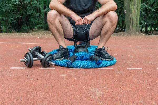 CrossFit ekipman üzerinde oturan adam
