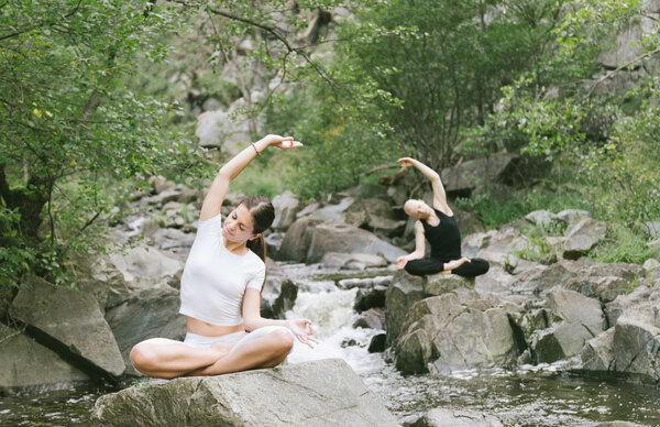 Man and woman doing yoga in nature..