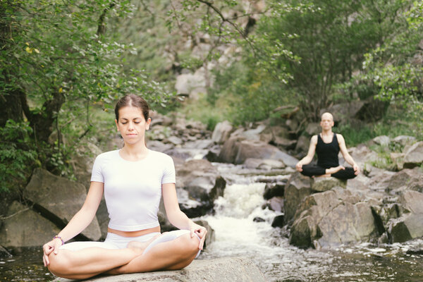 Man and woman doing yoga in nature..