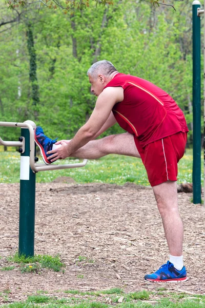 Senior Exercising In Sport Park Stock Photo