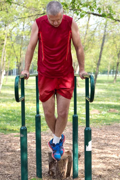 Senior Exercising In Sport Park Stock Photo