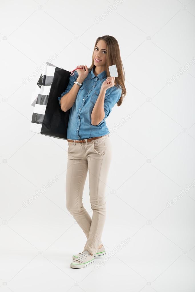 Attractive young woman with shopping bags and credit card