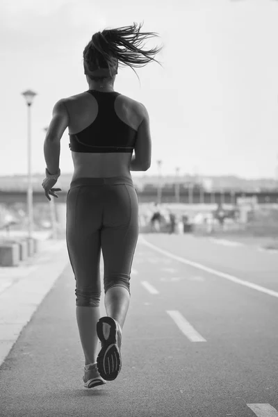 Mulher correndo na pista de corrida durante um treino . — Fotografia de Stock