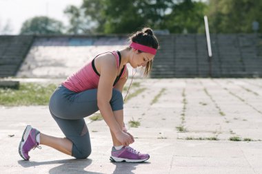 kadın onun ayakkabı bağcığı bağlama.