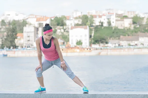 Mujer haciendo ejercicios de calentamiento antes de correr . — Foto de Stock