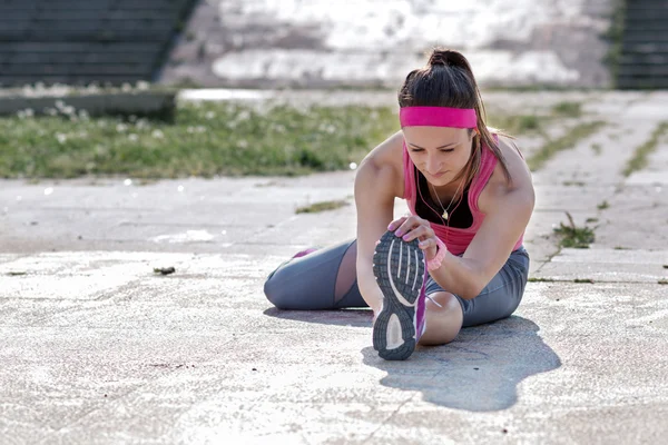 Woman doing  warm-up exercises before running.