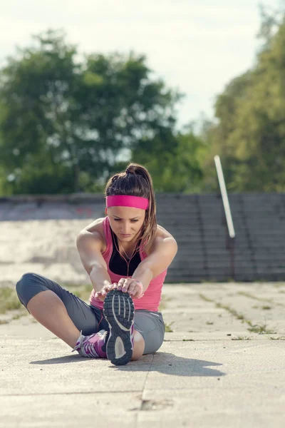 Woman doing  warm-up exercises before running.