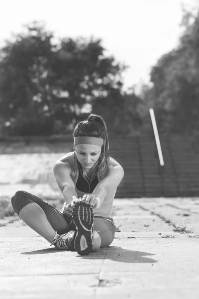 Mujer haciendo ejercicios de calentamiento antes de correr . — Foto de Stock