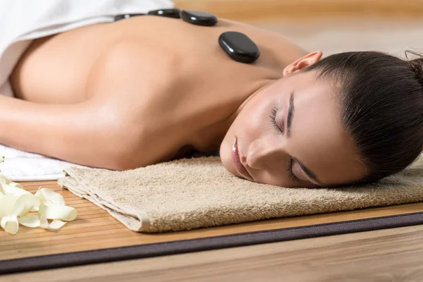 Donna con massaggio con pietre calde . — Foto Stock