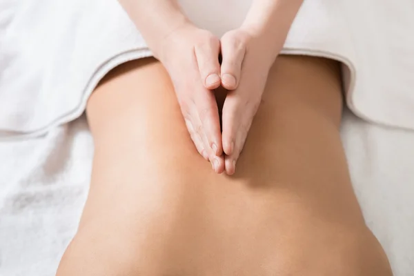 Fechar as mãos de uma massagista massagear as costas femininas . — Fotografia de Stock