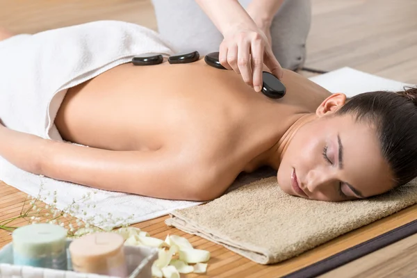 Mujer disfrutando del ritual de piedra caliente en el centro de spa . — Foto de Stock