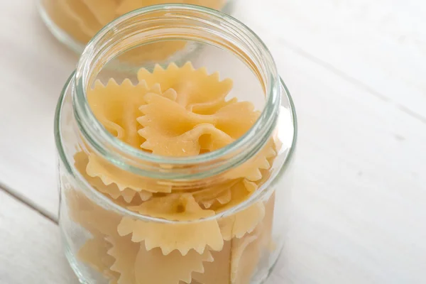 Varias pastas en tarros en la mesa blanca de madera . — Foto de Stock