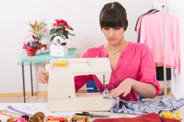 Mujer joven cosiendo en casa con papel de coser . — Foto de Stock