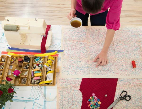 Mujer joven cosiendo en casa con papel de coser . — Foto de Stock