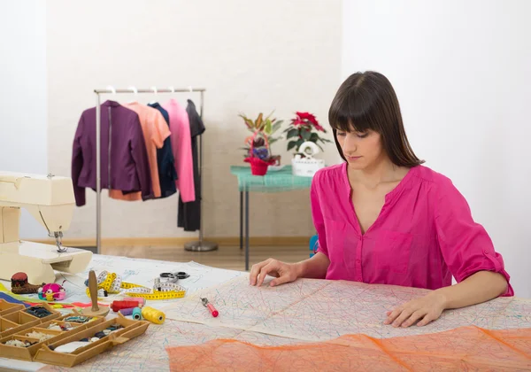 Mujer joven cosiendo en casa con papel de coser . — Foto de Stock