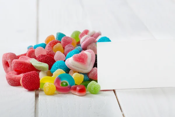 A lot of candies with greeting card. — Stock Photo, Image