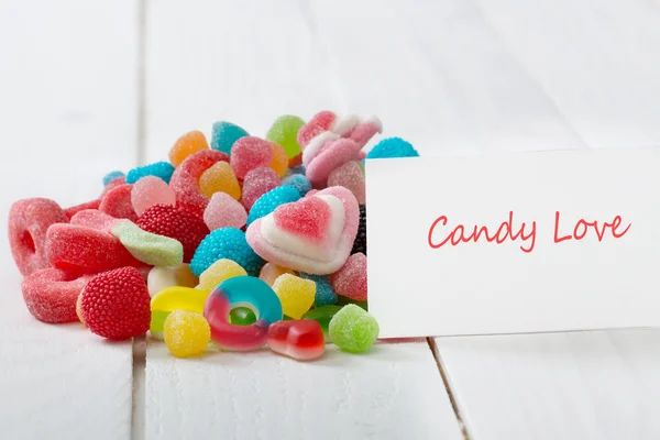 A lot of candies with greeting card. — Stock Photo, Image