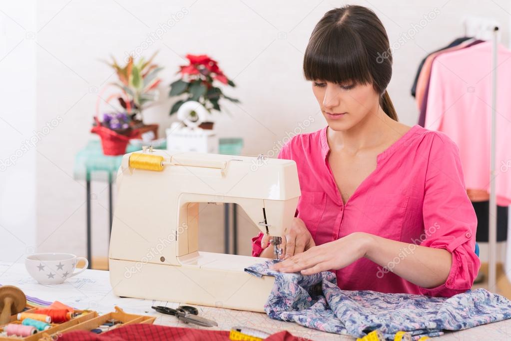 Young Woman sewing at home with sewing paper.