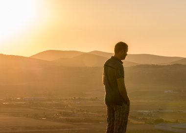 Ayakta uzaktan bakan genç adam