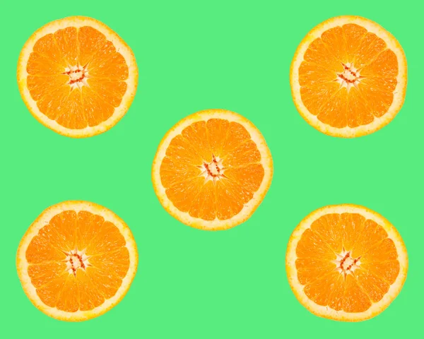 Slices of orange on green background — Stock Photo, Image