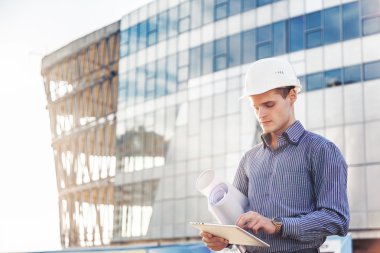 Portre genç foreman veya baş mühendis dijital tablet iş yerinde kullanır.