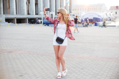 Şehir meydanında, bir selfie alarak genç güzel kadın