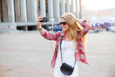 Şehir meydanında, bir selfie alarak genç güzel kadın