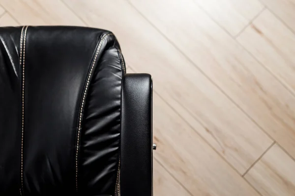 Black leather office chair, view from above. Office furniture background