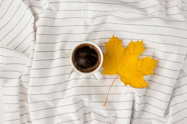 Composición de otoño. Taza de café, hojas de otoño sobre tela blanca a cuadros. Plano, vista superior, espacio para copiar — Foto de Stock