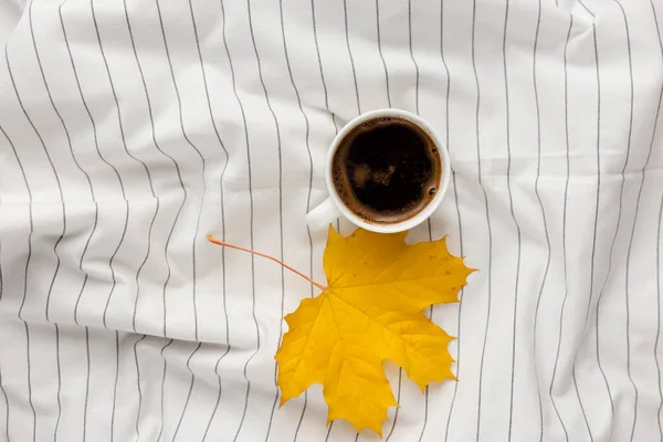 Composición de otoño. Taza de café, hojas de otoño sobre tela blanca a cuadros. Plano, vista superior, espacio para copiar — Foto de Stock