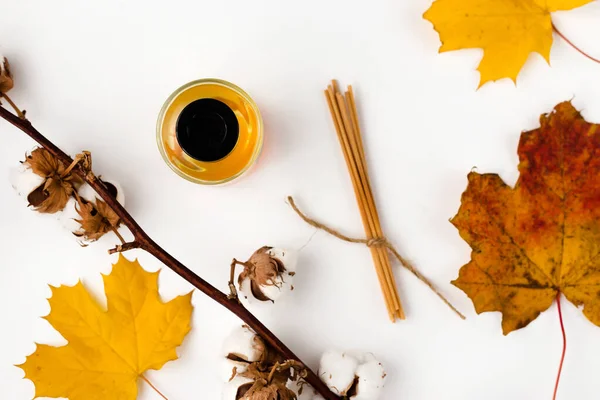 Autumn vibe composition. Blank greeting card mockup. PErfume jar, colorful maple leaves. White table background. Flat lay, top view. — Stock Photo, Image