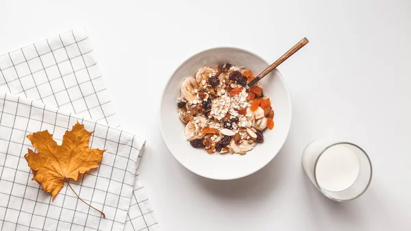 Carbohydrate healthy breakfast. Oatmeal with dried fruits on a white plate. View from above — Stock Photo, Image