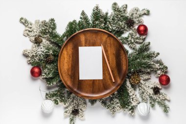 Tahta tabakta boş kart ve noel ağacı dalları olan bir zarf. Yılbaşı ve yeni yıl konsepti düzleşti. Üst görünüm