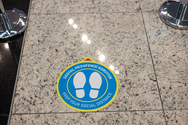 Keep Your Social Distance sign on airport floor. Coronavirus Covid-19.