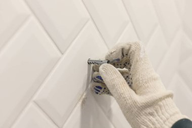 İşçiler eldiven takar duvara seramik seramik kaplamalı pvc panel yerleştirir