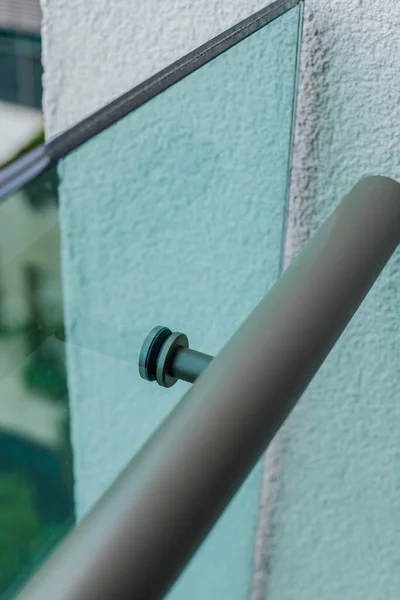 Fixation métallique des mains courantes à la cloison en verre du balcon. — Photo