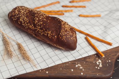 Kesme tahtasında dilimlenmiş çavdar ekmeği. Tohumlu tam tahıllı çavdar ekmeği.