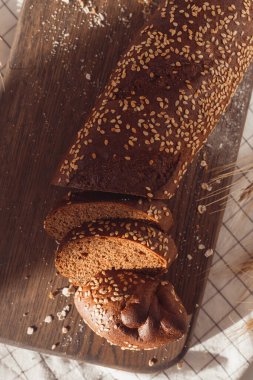 Kesme tahtasında dilimlenmiş çavdar ekmeği. Tohumlu tam tahıllı çavdar ekmeği.