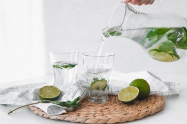 Limon meyveli detoks suyu. Kireç suyunu sürahiden bardaklara dökerek.