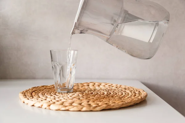 Verter agua de la jarra en un vaso — Foto de Stock