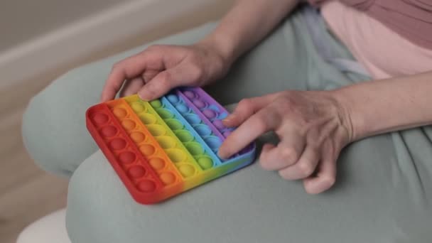 Жінка грає з кольоровими силіконовими антистресовими іграшками поп-це — стокове відео