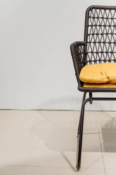 Черный плетеный стул с желтыми подушками. Подробности — стоковое фото